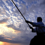 young aikido man fighter at sunset light