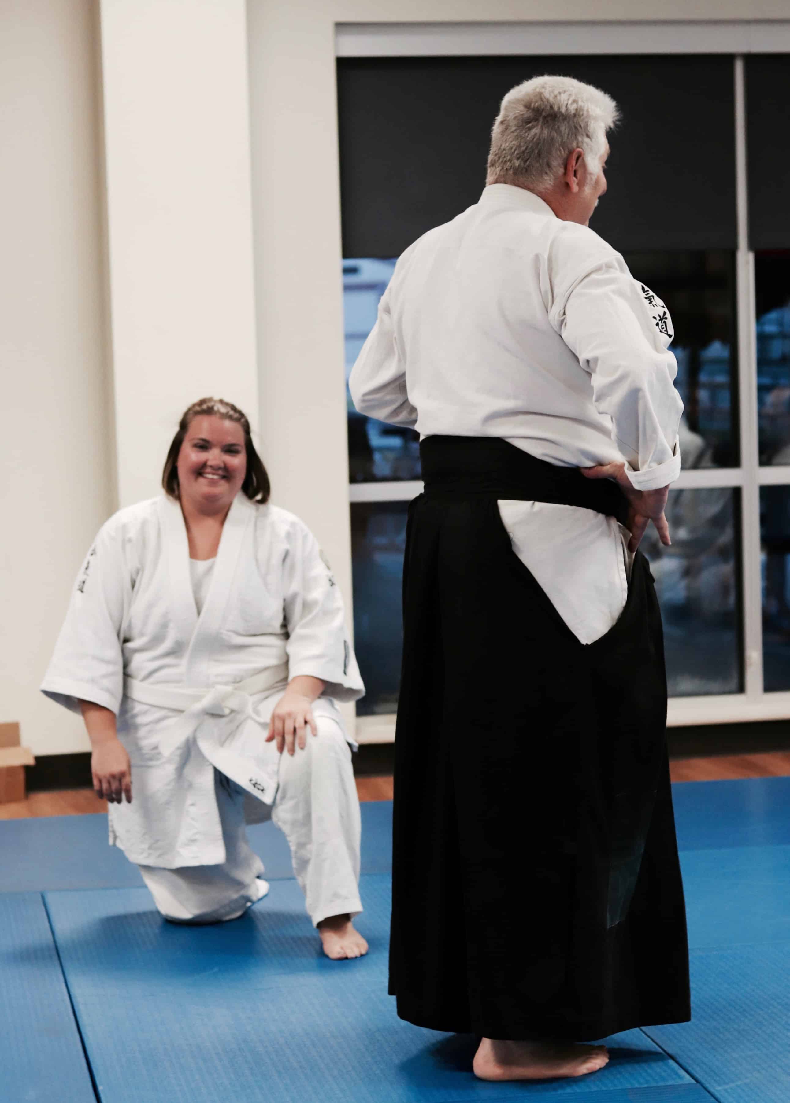 Aikido student smiling while Sensei Mike teaches a class